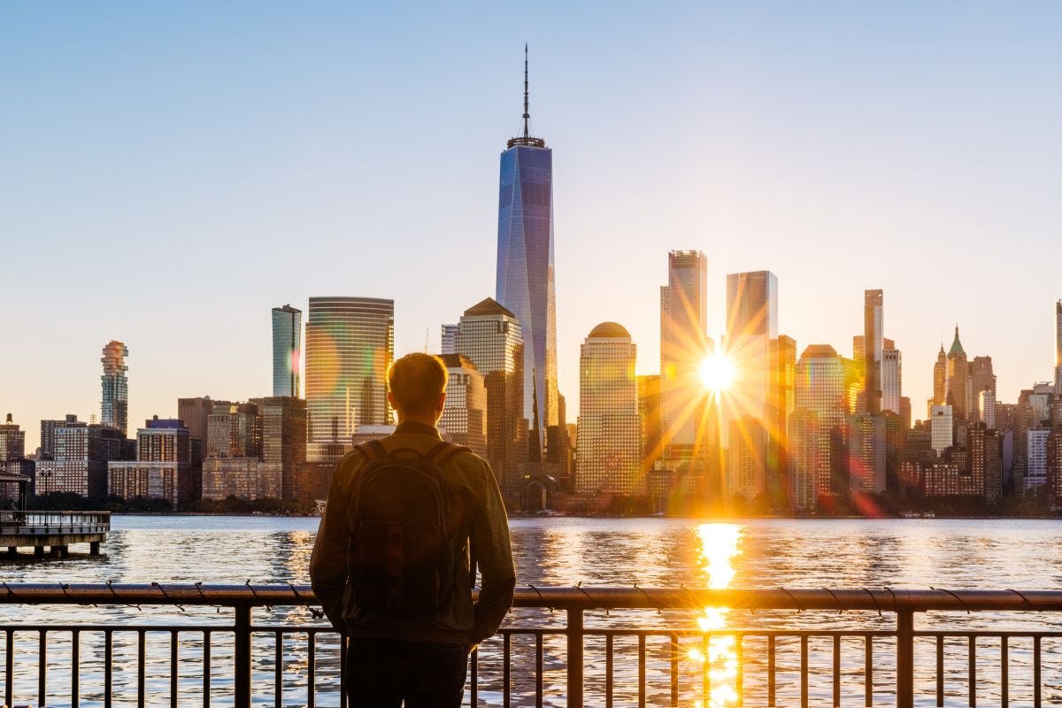 Man with backpack looking at NYC skyline