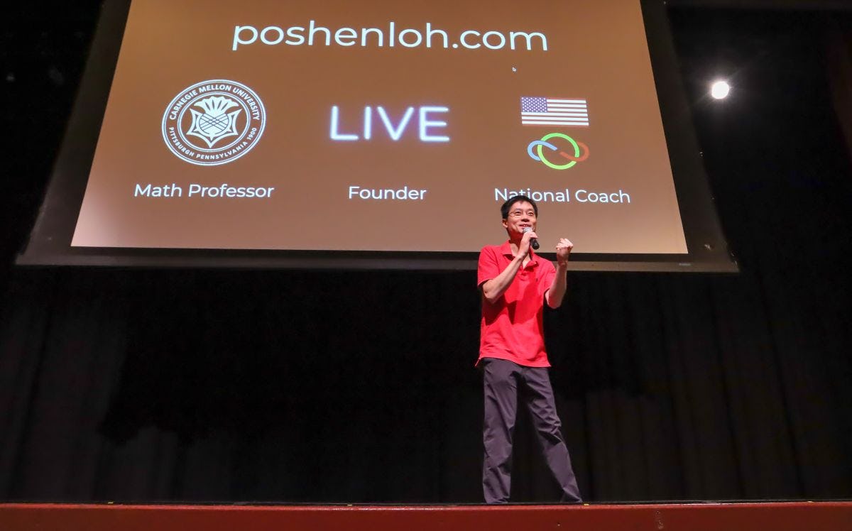 Po-Shen Loh speaking on stage in DeBaun Auditorium