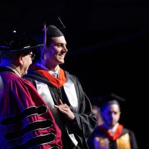 A student received his diploma from Stevens President Nariman Farvardin at the 2022 Undergraduate Commencement Ceremony.