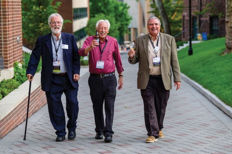 Three Stevens alumni smile for the camera as they walk up Whittpenn walk.