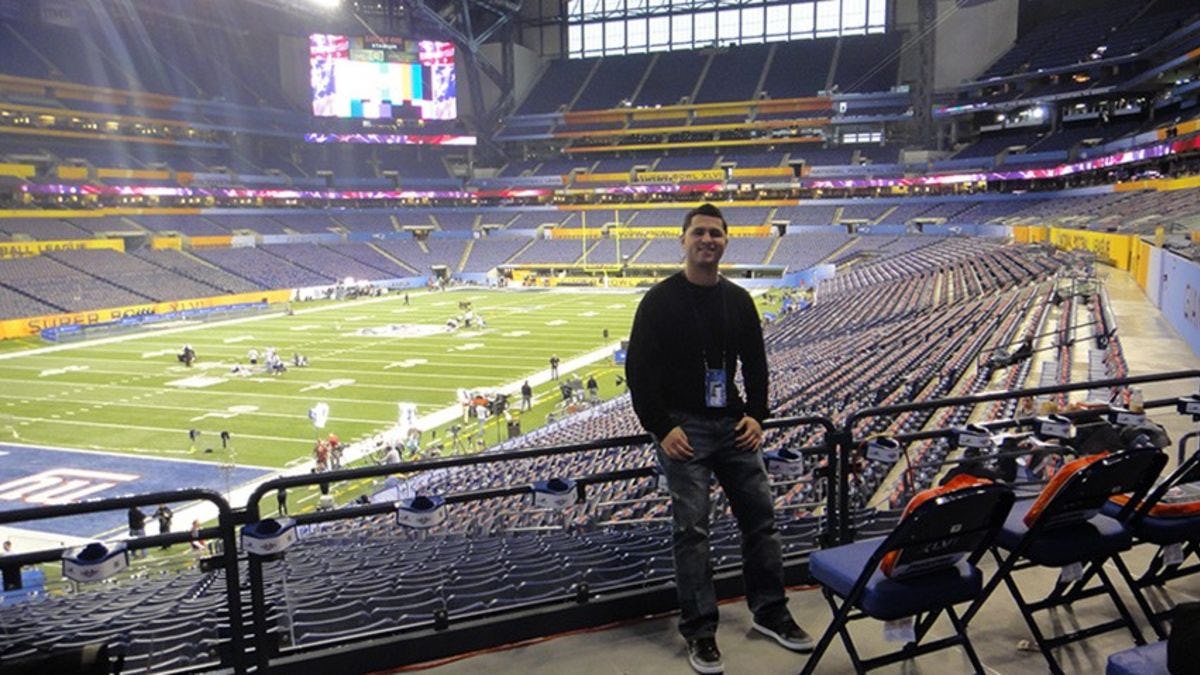 Alex Semidey at an empty football stadium in Indianapolis ahead of Super Bowl XLVI