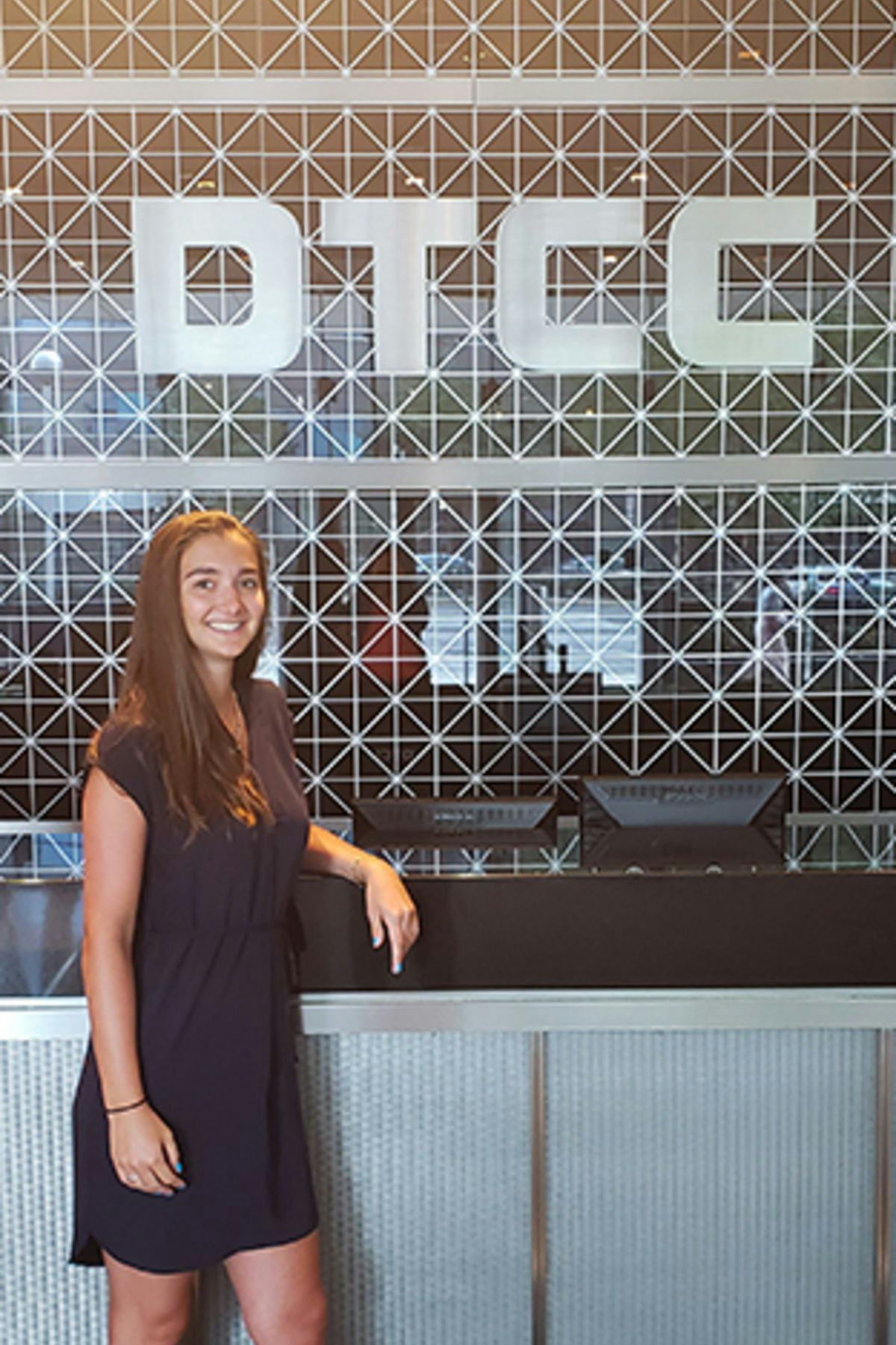 Zenya Koprowski in front of the DTCC sign at her internship.
