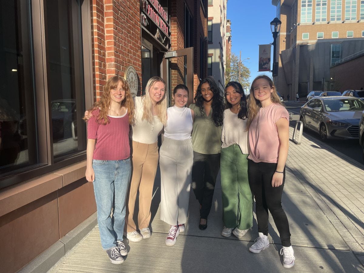 Six female Stevens students stand together on a sidewalk in Hoboken.