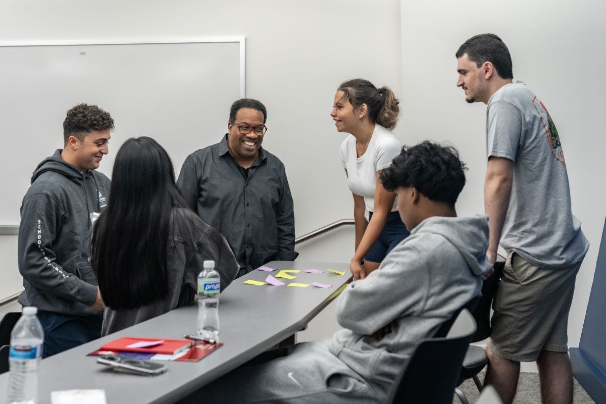Kevin Pitts smiles while speaking with a group of students during the Inclusive Leadership Program