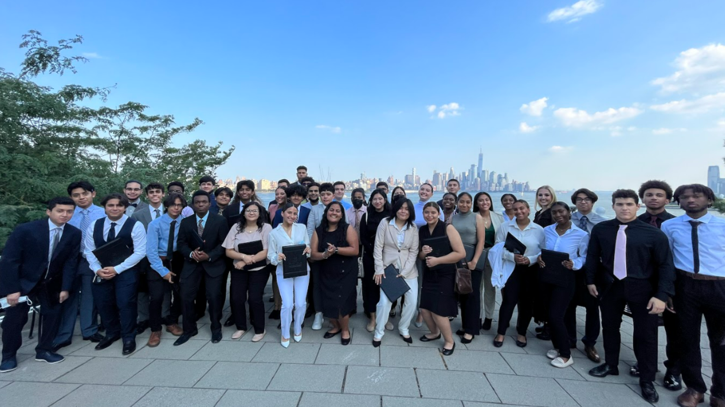 Group of students posing in front of New York Skyline