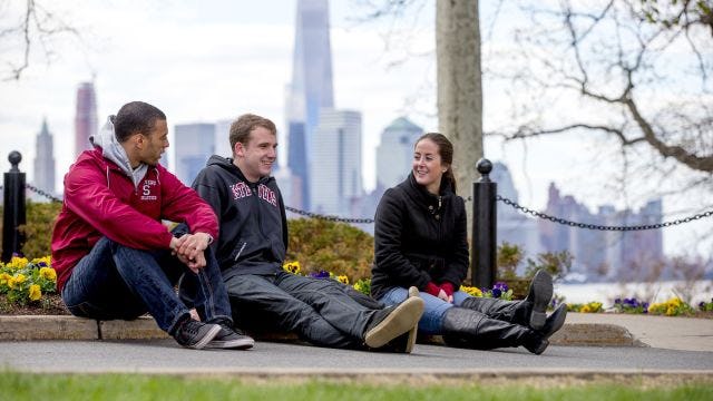 Students sitting on the campus lawn at Stevens Institute of Technology 