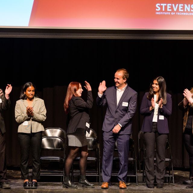Students celebrate on stage at Innovation Expo