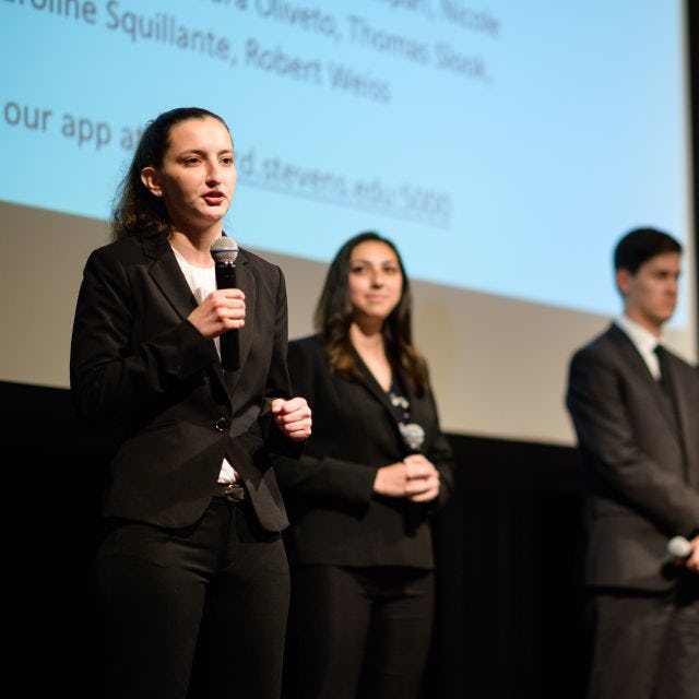 students presenting project at professional event