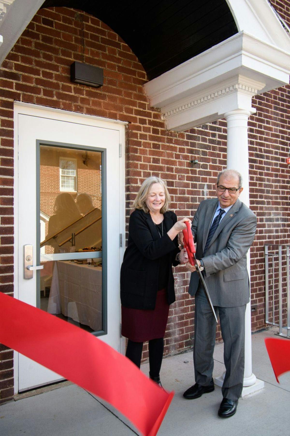 From left to right: Marybeth Murphy, vice president for enrollment management and student affairs, and Stevens President Nariman Farvardin cutting a red ribbon outside the entrance of the Student Wellness Center