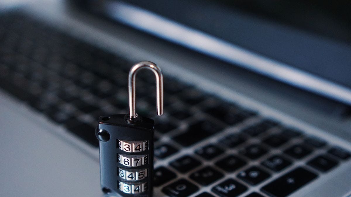 A stock image of an open lock in front a laptop keyboard.