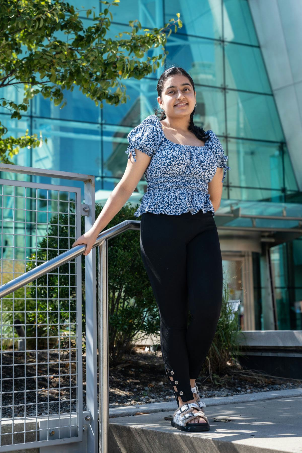 Tanya Avadia stands next to a staircase outside of the Babbio Center