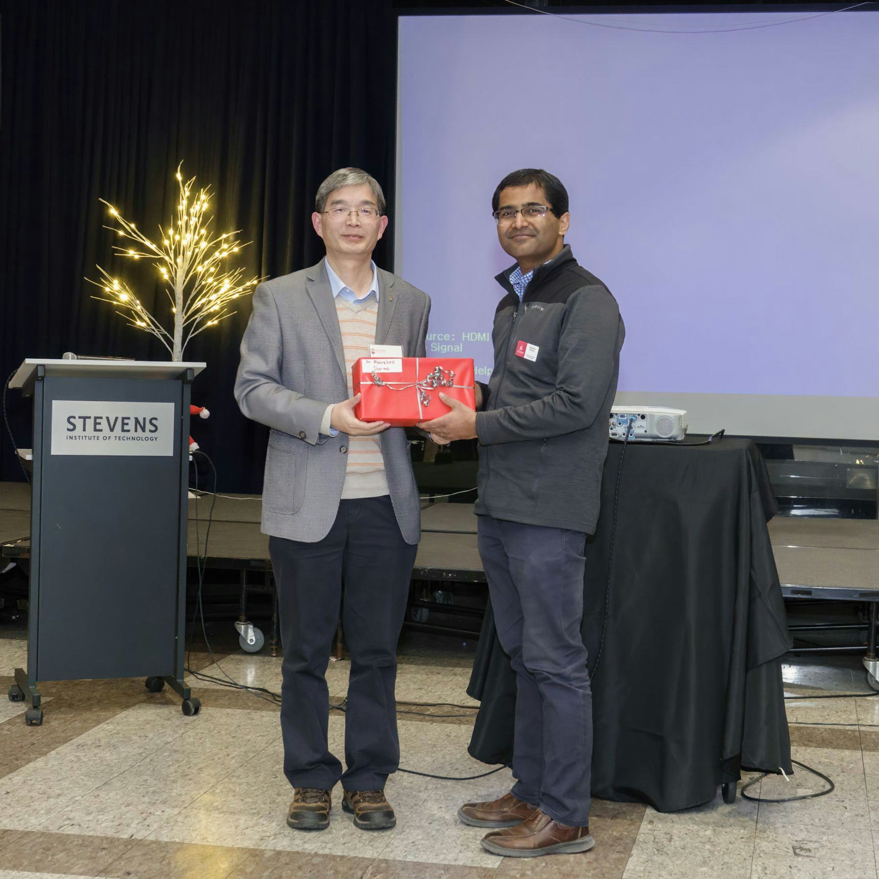 Yong Zhang and Abhishek Sharma standing together holding an award