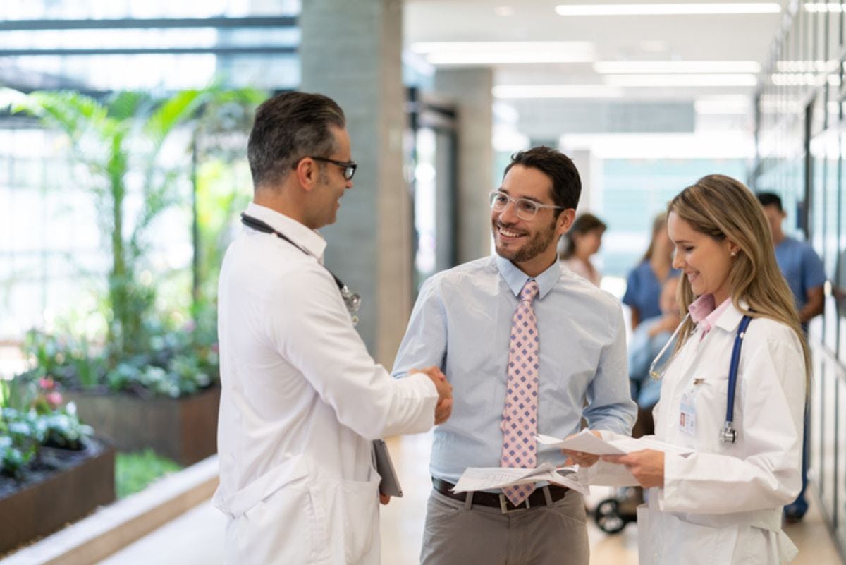 businessman shaking hand with healthcare worker
