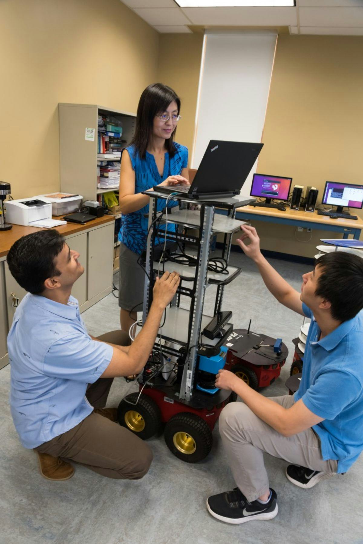 Guo and students Muhammad Fahad and Chao Jiang in the Robotics and Automation Laboratory
