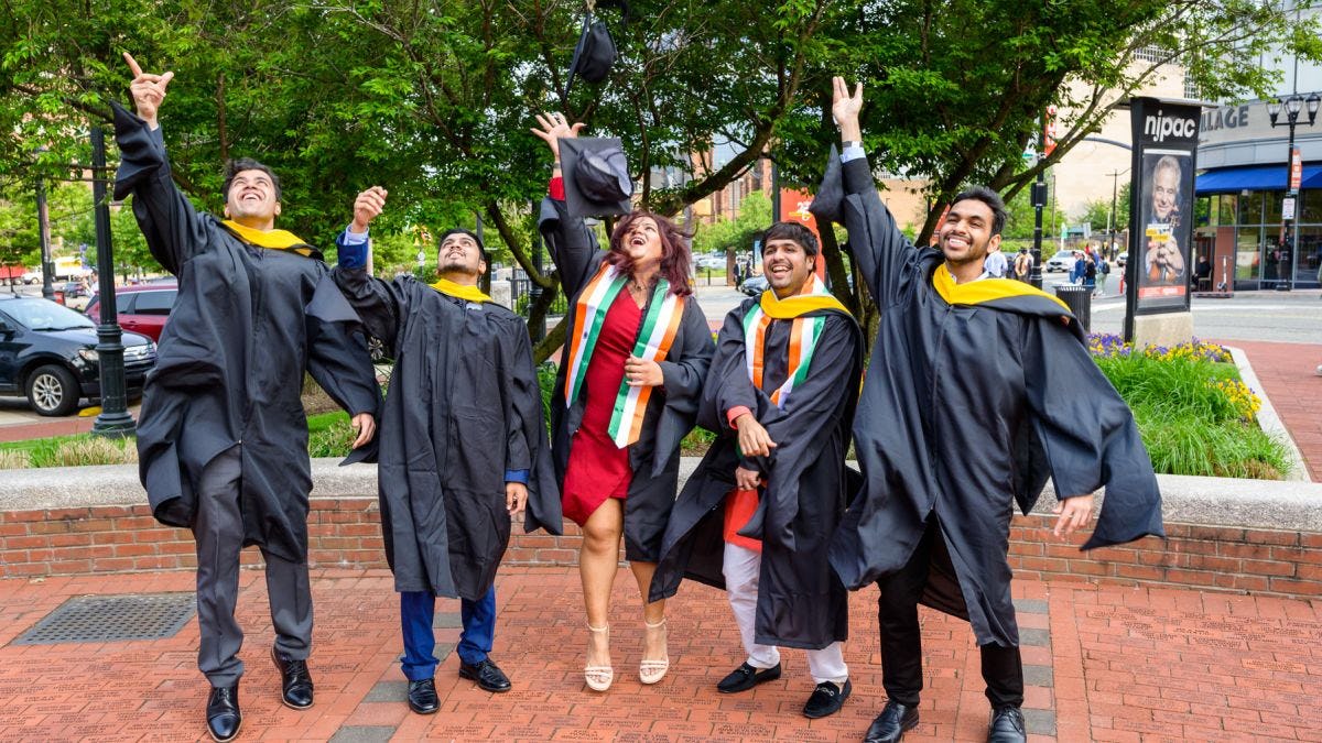 Group of graduates toss their caps into the air to celebrate graduation