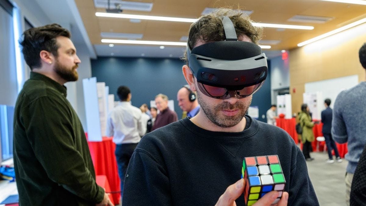 Attendee wearing VR goggles and holding Rubik's Cube at Stevens event