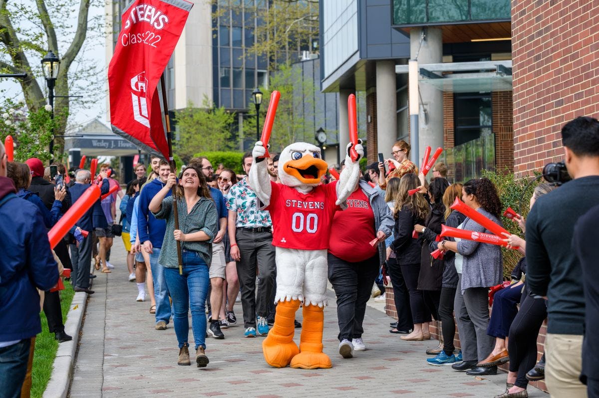 Graduating students walk on Wittpenn Walk with Attila and cheering crowds