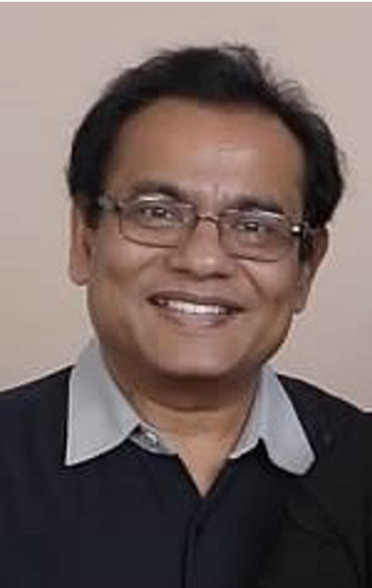 Head shot of Tribikram Kundu, wearing glasses and smiling
