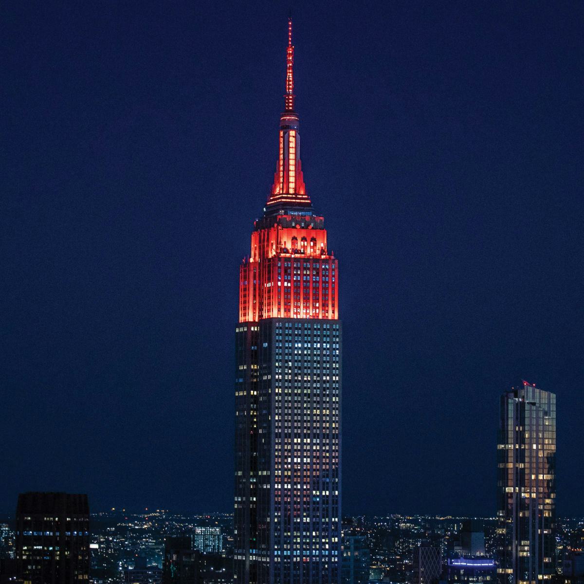 Empire State building at night lit up in Stevens red.