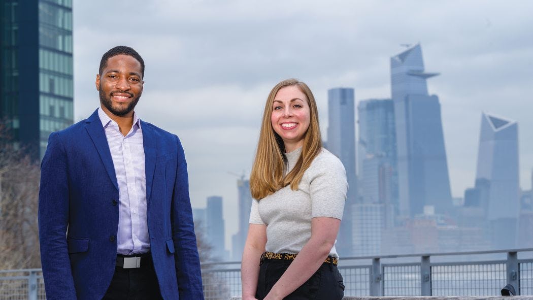 School of Systems and Enterprises professor Philip Odonkor and graduate student Danielle Preziuso standing on campus in front of the New York skyline.