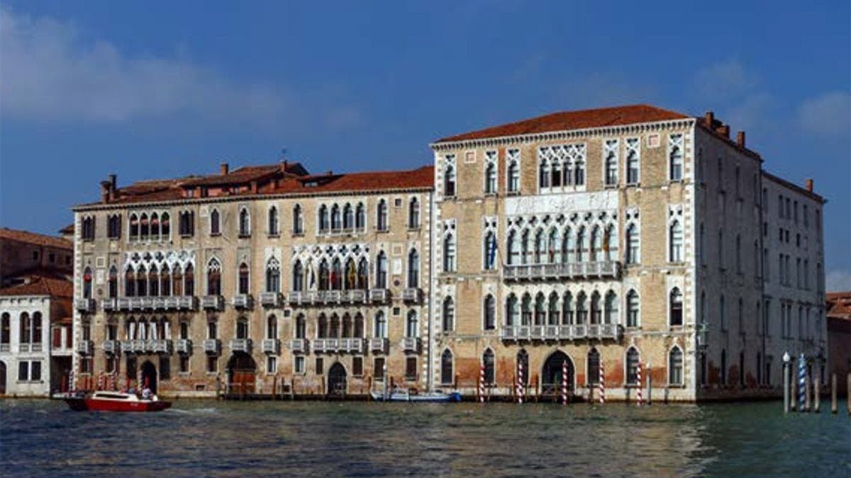 A building on the Ca' Foscari University of Venice campus. A canal and riverboat are visible in the foreground.