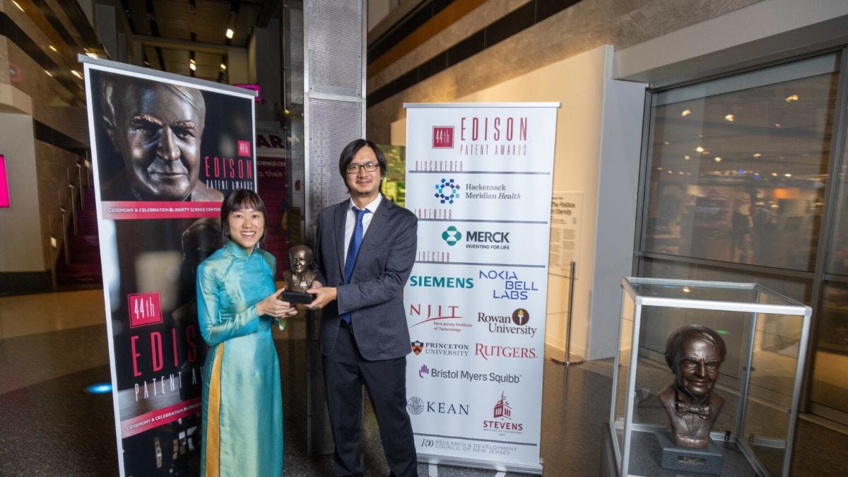 Stevens alumna Lac Nguyen and professor Yuping Huang pose with trophy at Edison Patent Awards Ceremony in November 2023