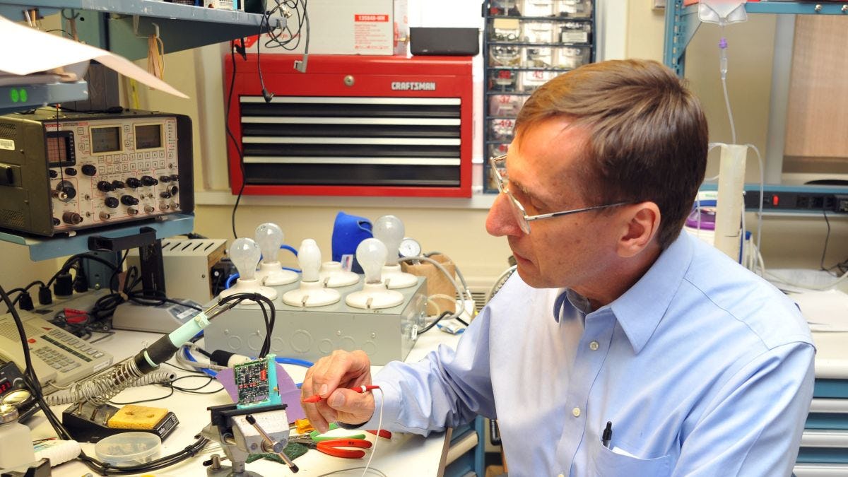 Herman Morchel M.Eng. '80 working with biomedical equipment in the lab at Hackensack University Medical Center