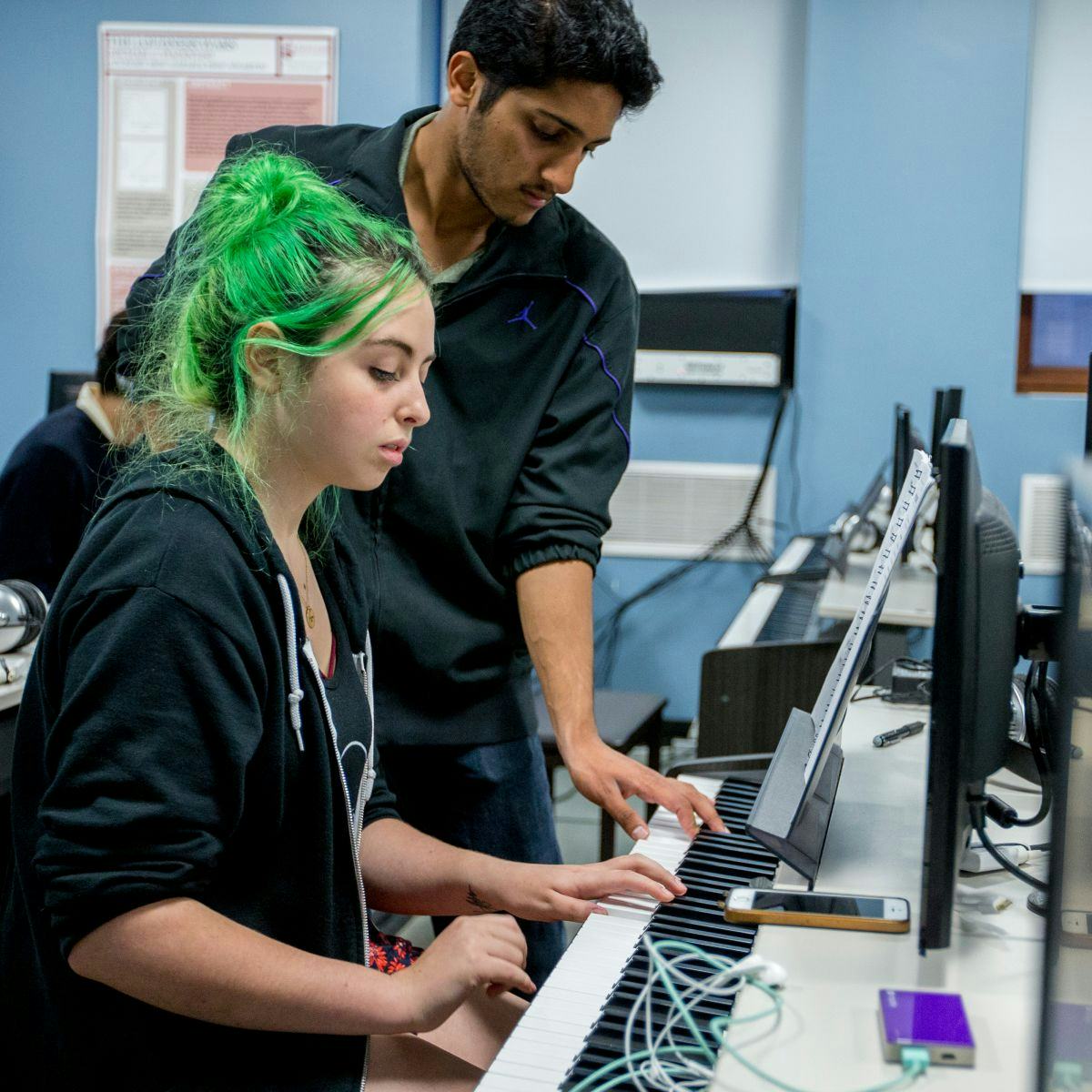 Two students play keyboard together