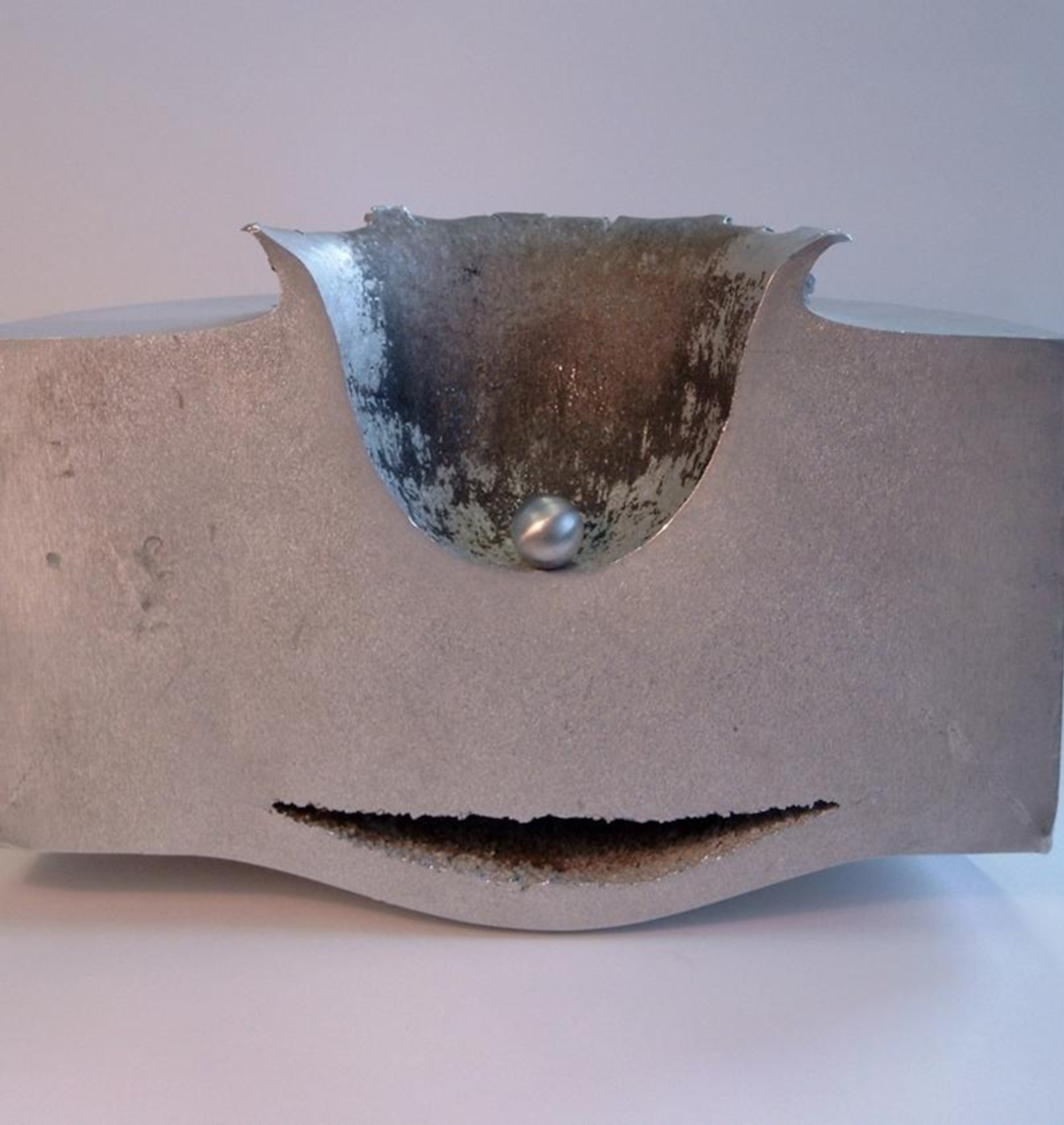 This image shows the results of a lab test impact between a small sphere of aluminum travelling at approximately 6.8 km/second and a block of aluminum 18 cm thick.