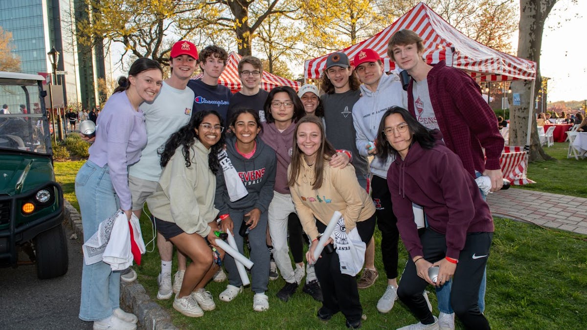 Group of students pose together for the camera at a festival on campus.