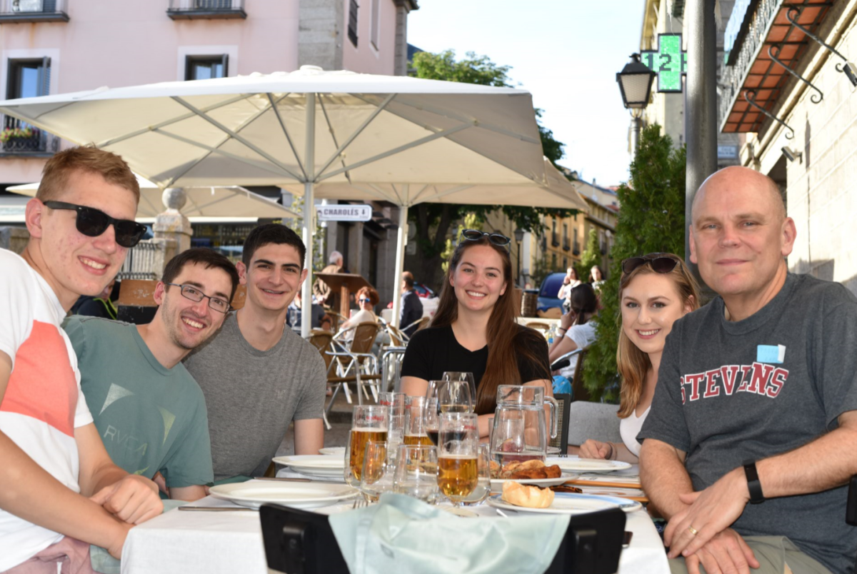 Six students smile at outdoor restaurant while studying abroad 