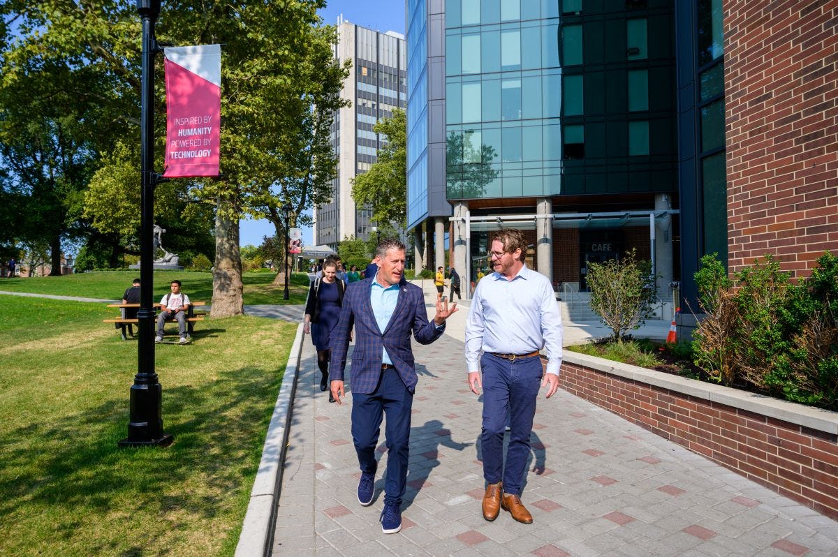 Greg Townsend walks with New Jersey State Senator Andrew Zwicker on campus.