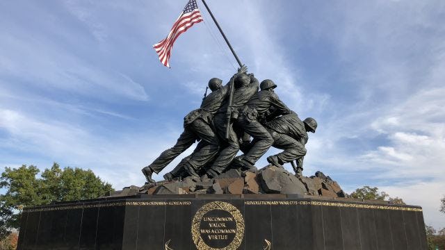 Marine Corps soliders lifting American flag statue