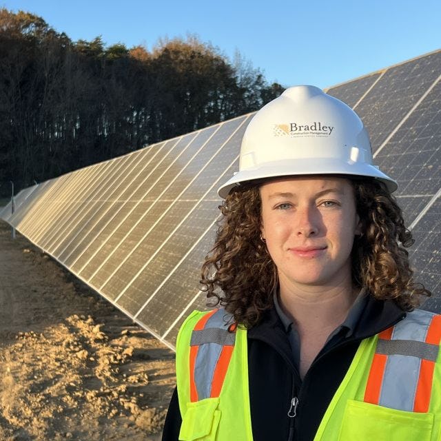 Jessica Driscoll stands in front of solar panels