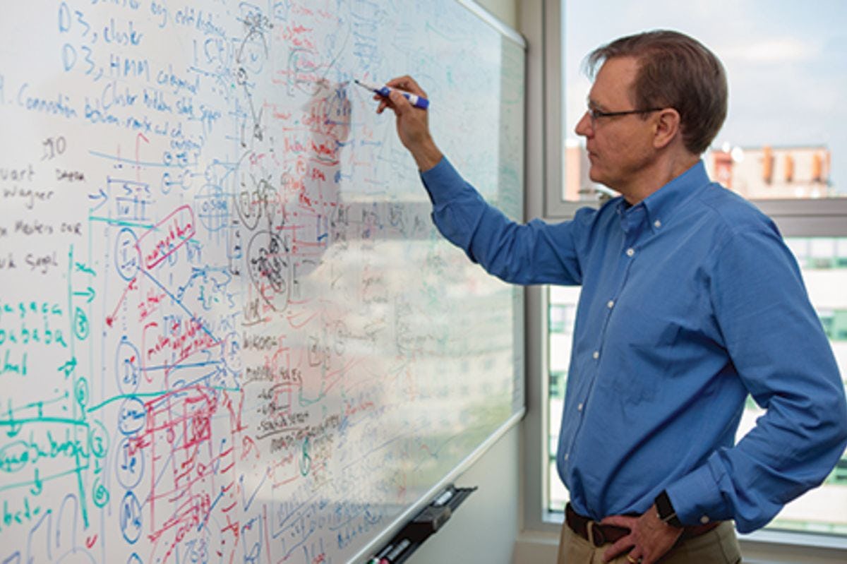 Dr. Jeff Nickerson in a blue shirt working on a whiteboard in his office in Hoboken.