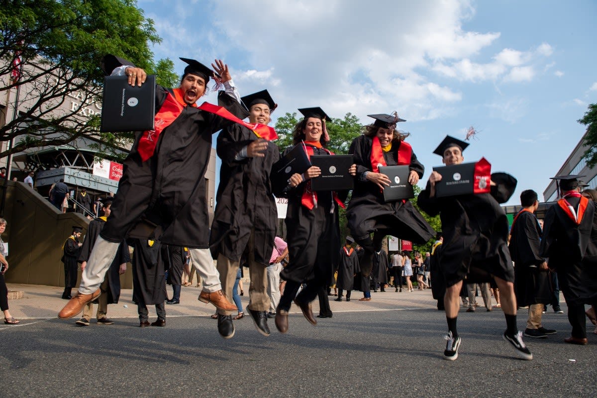 Male graduates jumping