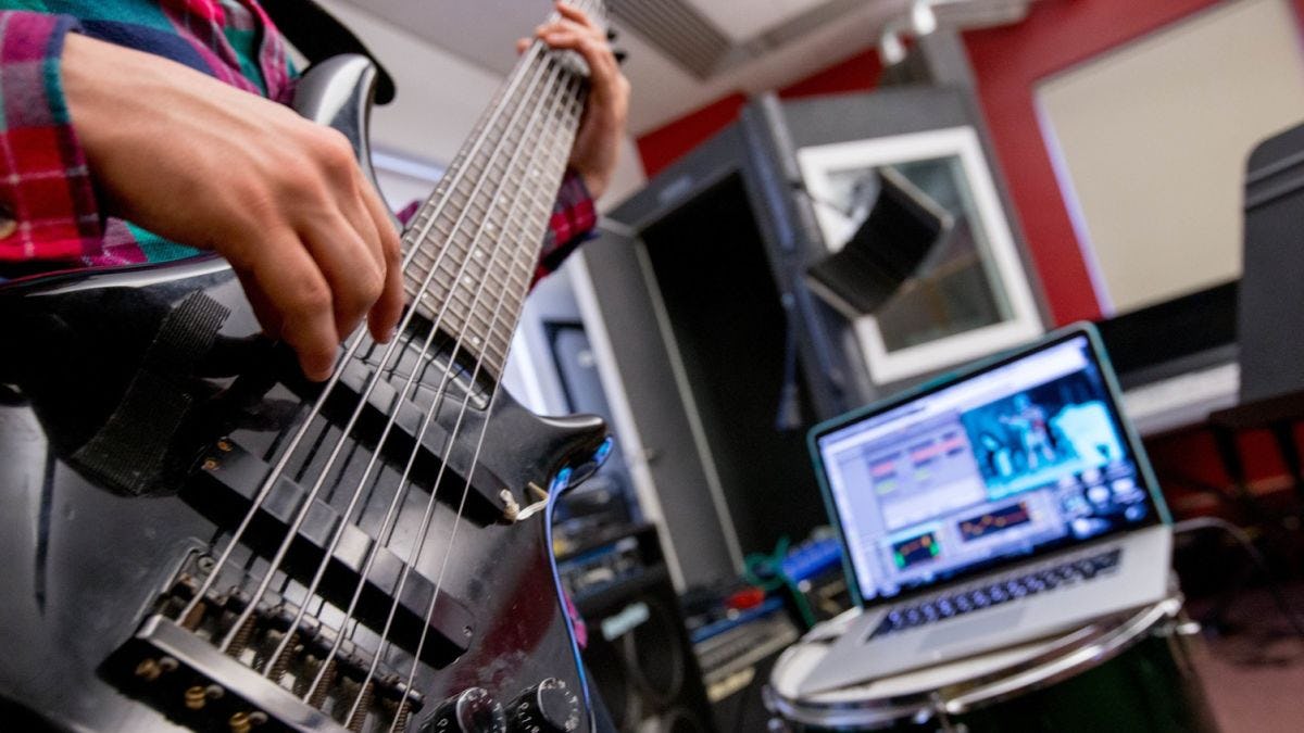 Student playing an electric guitar in Stevens music lab