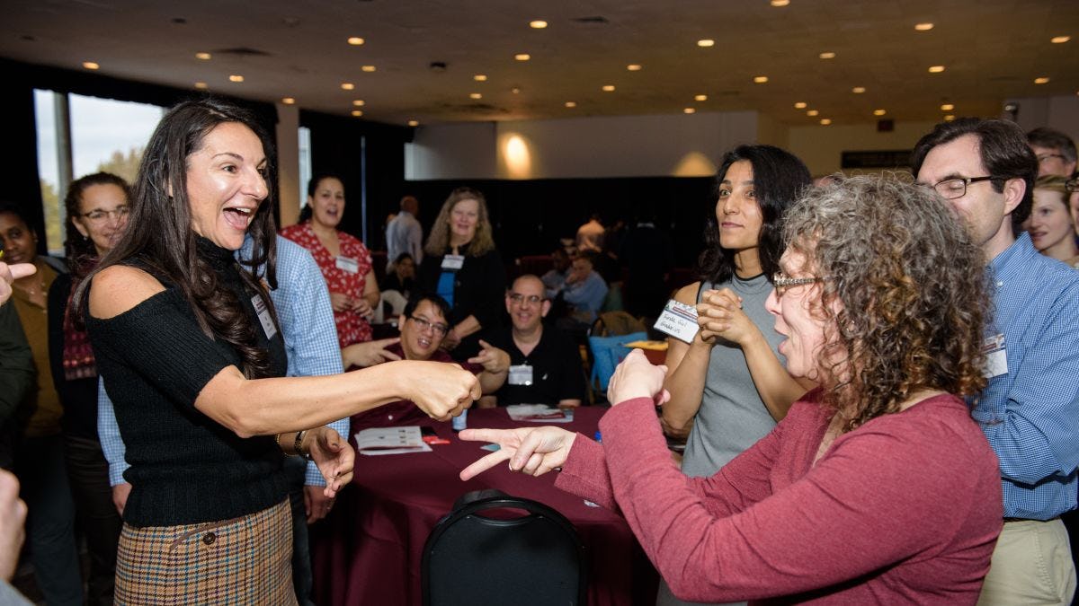 CAPTION: participants engage in a rock—paper—scissors tournament at the Reimagining Math Education conference. CREDIT: Jeff Vock