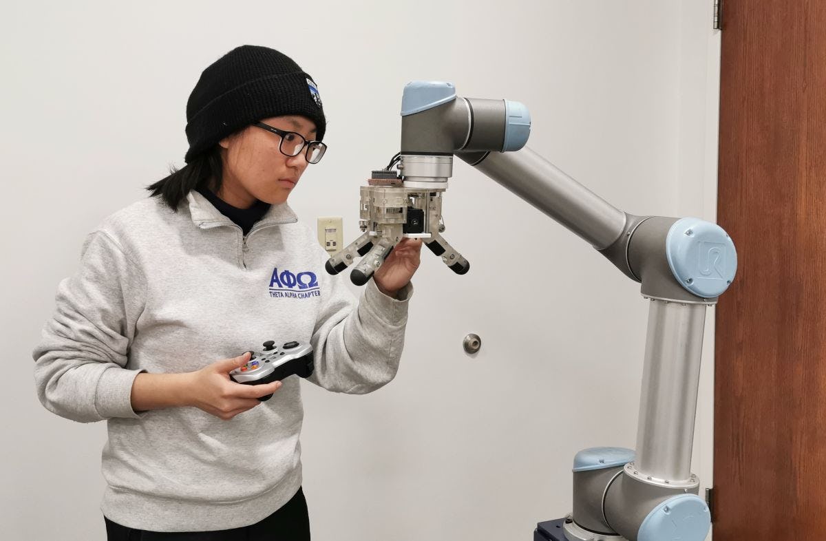 A student in Long Wang's laboratory working with the robotic hand