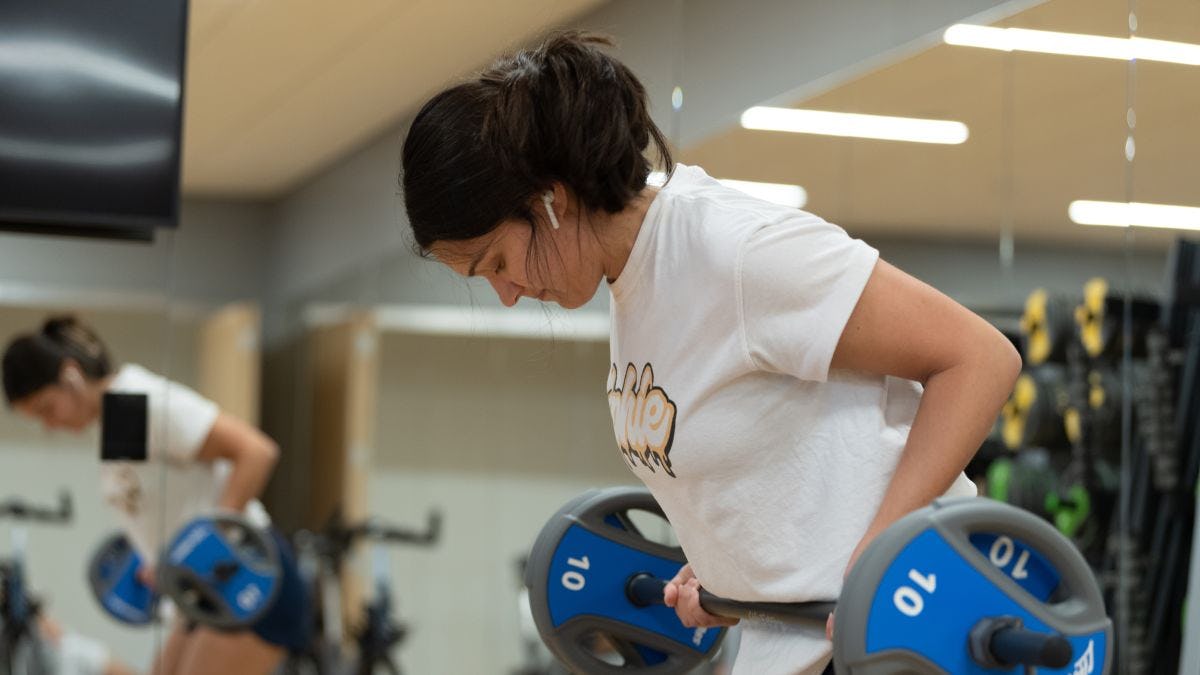 Student lifts weights in the UCC fitness center.