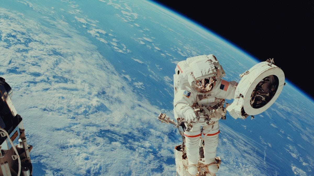 Astronaut floating in space with Earth behind him