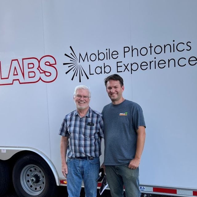 Professor Ed Whittaker and Bill Warger ’03 in front of the Thorlabs Mobile Photonics Lab Experience