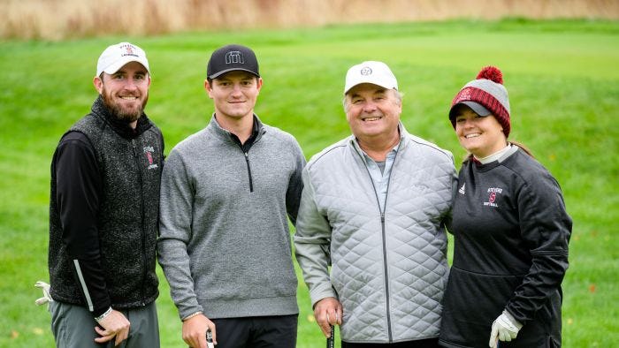 Four Stevens alumni gather on a course to play golf