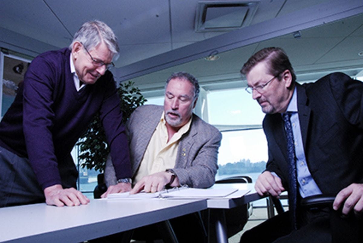 Three researchers reviewing a document