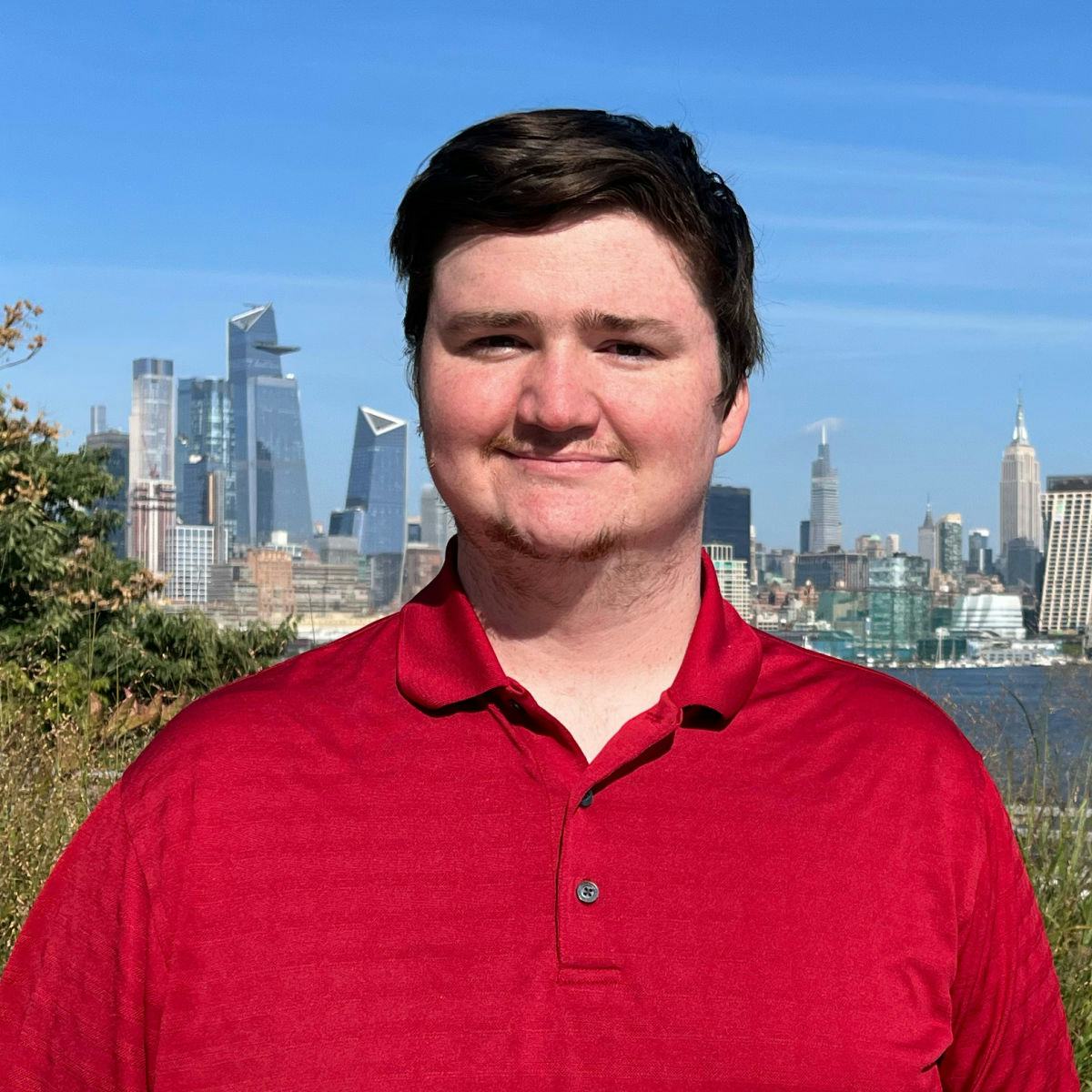 A headshot of Timothy Borin in front of the Hudson River