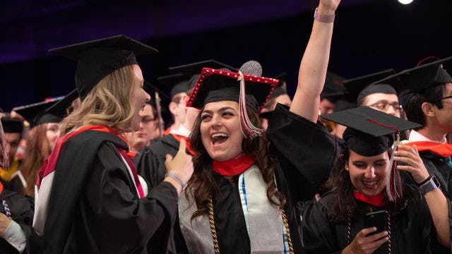 Students celebrate graduation with a big smile.