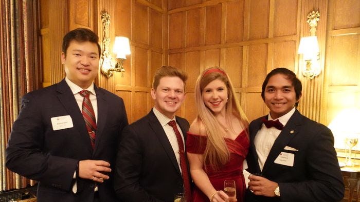 Four alumni pose for picture at 2021 DC holiday party 