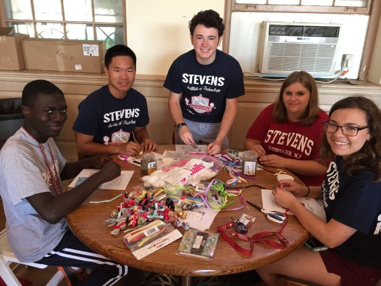 5 students at a table working on a Community Service project