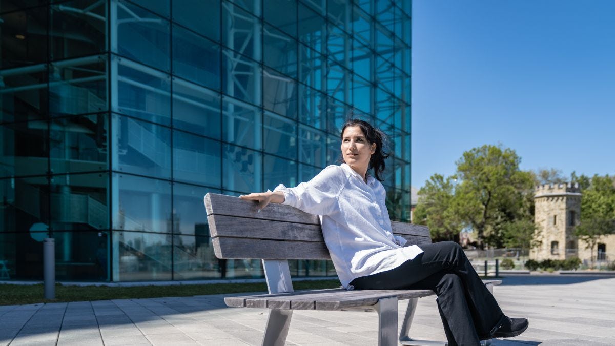 Seddiqa Hussein sitting on a bench outside