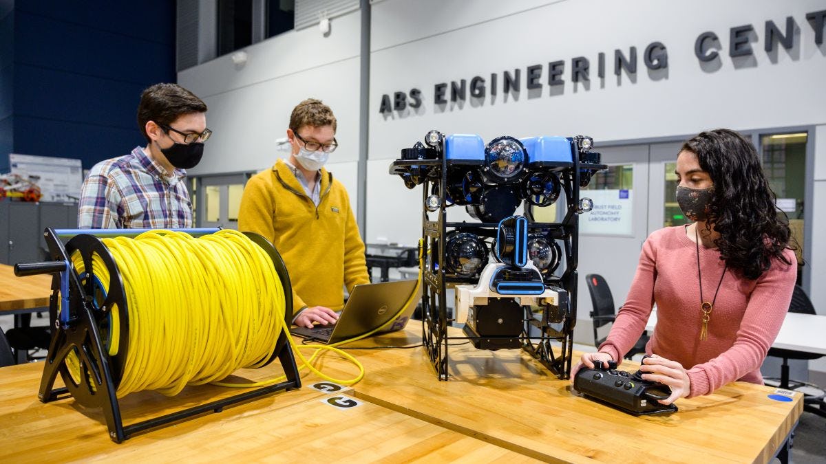 Three students work on underwater drone in the ABS Engineering Center.